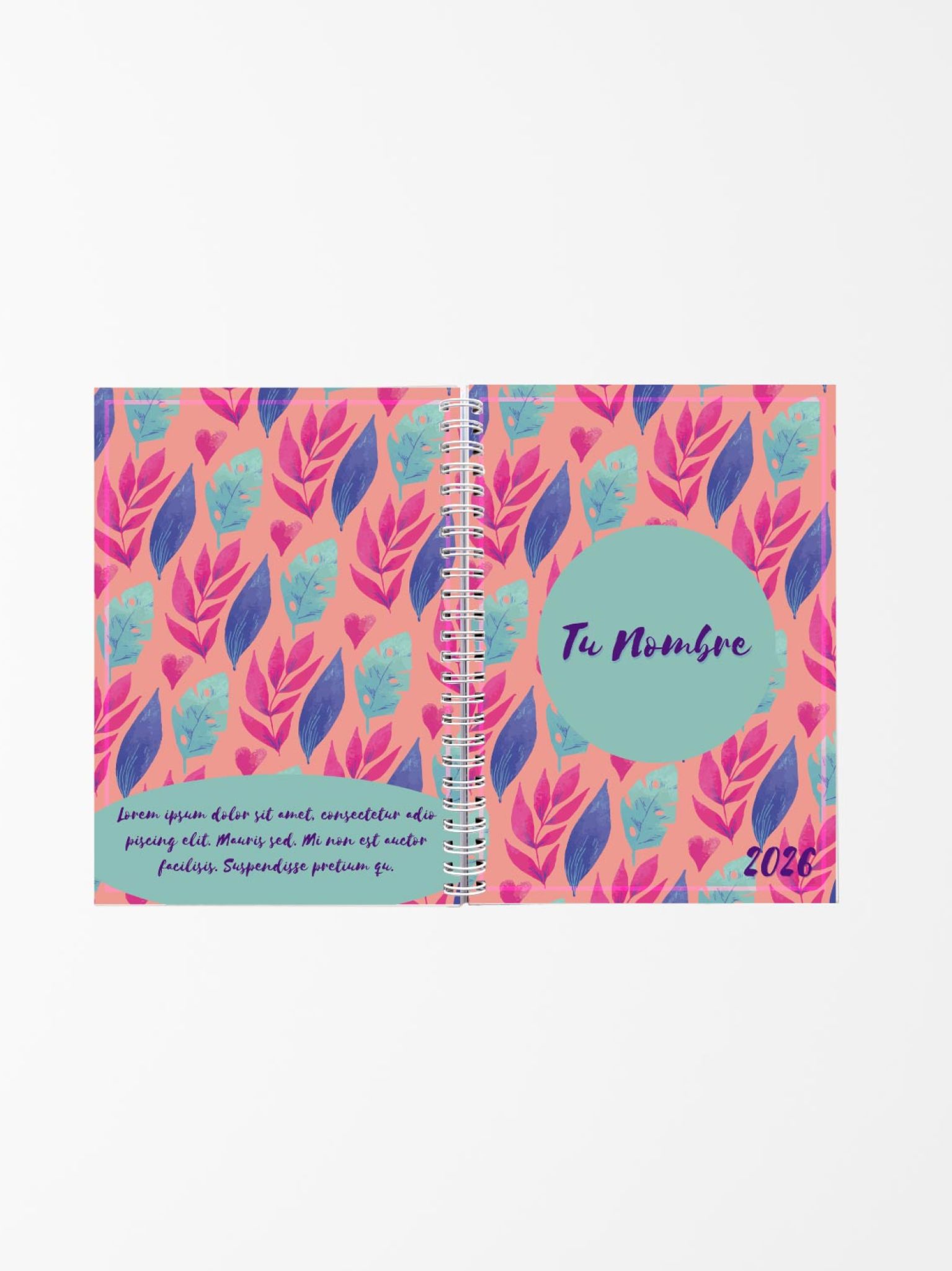 vista abierta de una agenda personalizada con fondo coral y patrón de hojas rosadas y azules, encuadernada con espiral blanca y texto "Tu Nombre 2026"