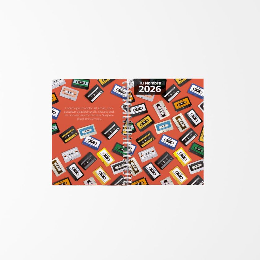 libreta personalizada abierta con diseño de cintas de casete sobre fondo naranja, con texto “Tu Nombre 2026” y encuadernación en espiral central