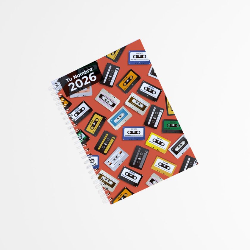portada de libreta personalizada con fondo naranja y estampado de cintas de casete de colores, encuadernada con espiral lateral y texto “Tu Nombre 2026”