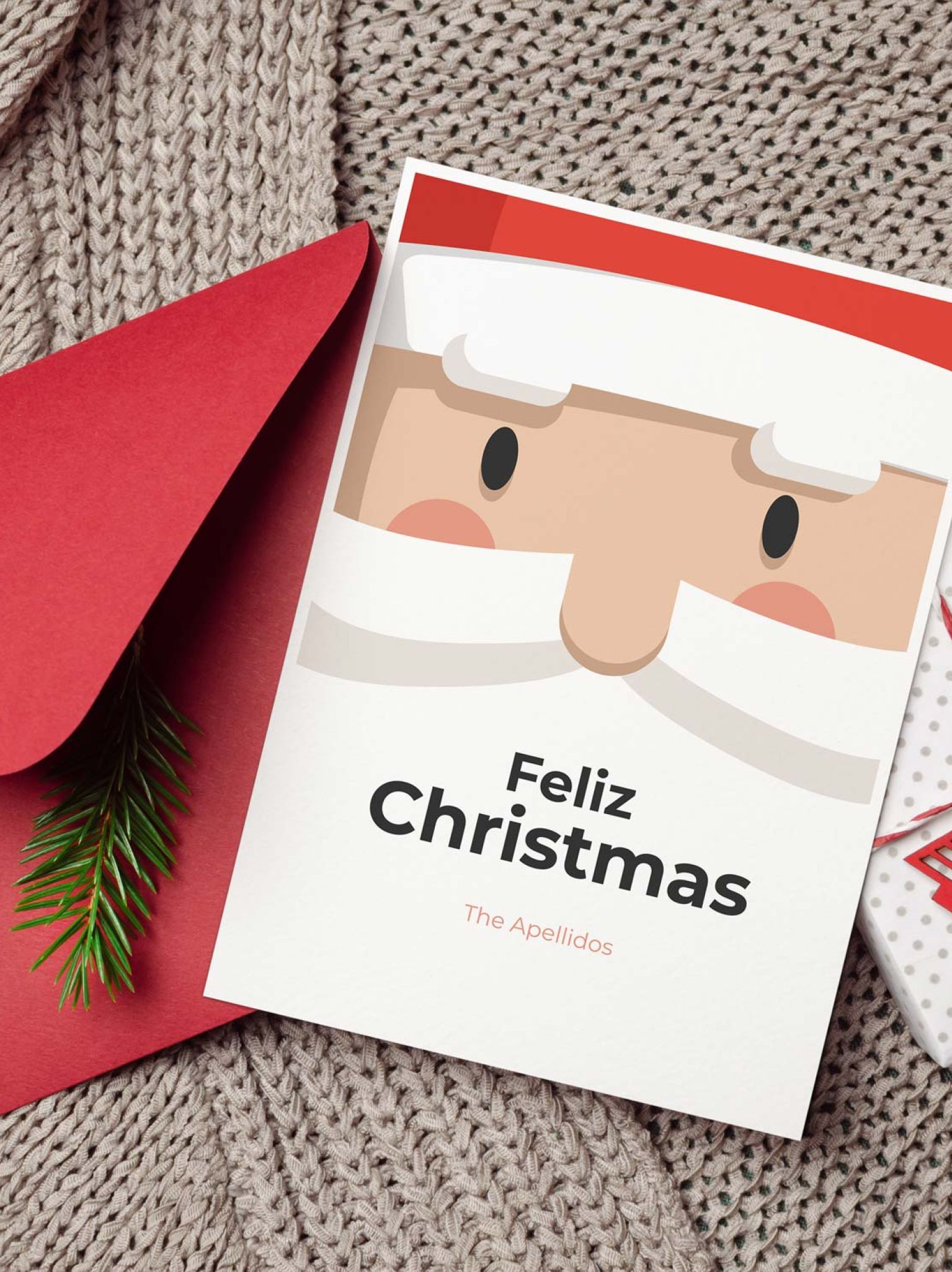 Tarjeta de Navidad con Papá Noel junto a sobre rojo, decoración y regalo navideño
