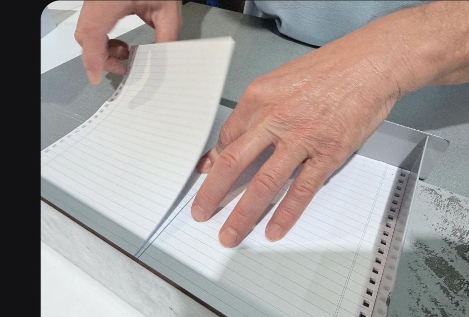 manos fabricando una libreta