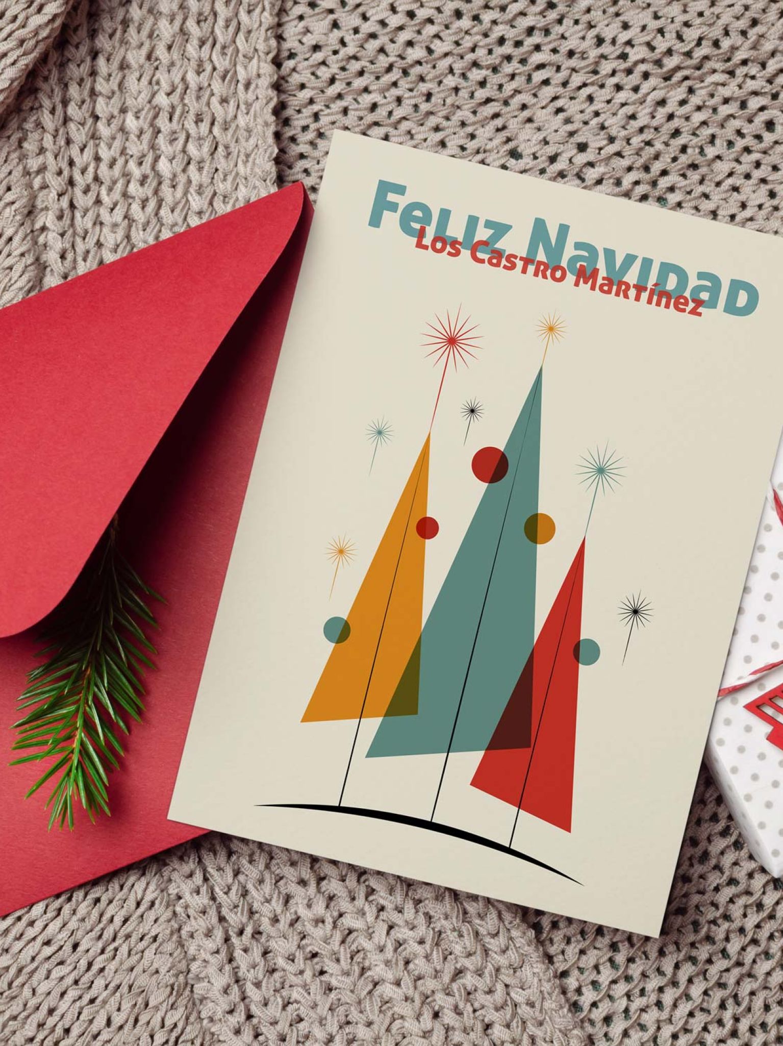 Mockup de tarjeta navideña personalizada junto a sobre rojo, cuerda y regalo envuelto