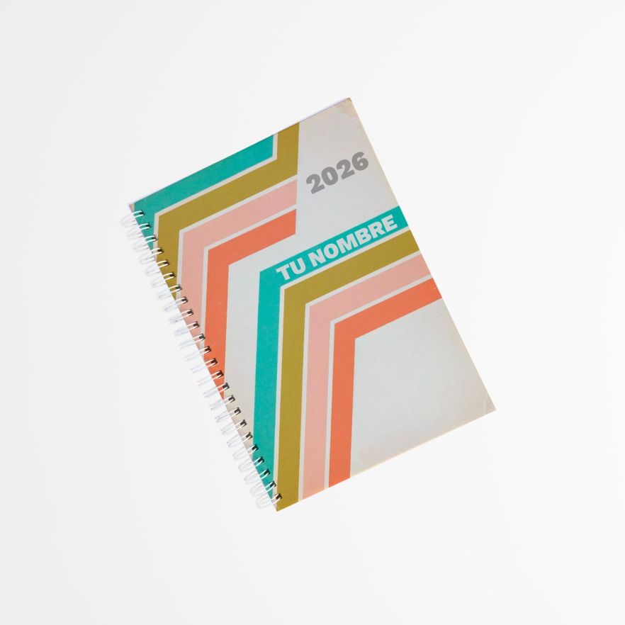 vista superior de una agenda con portada vintage, fondo beige y franjas diagonales en tonos verde, coral y mostaza, encuadernada con espiral lateral