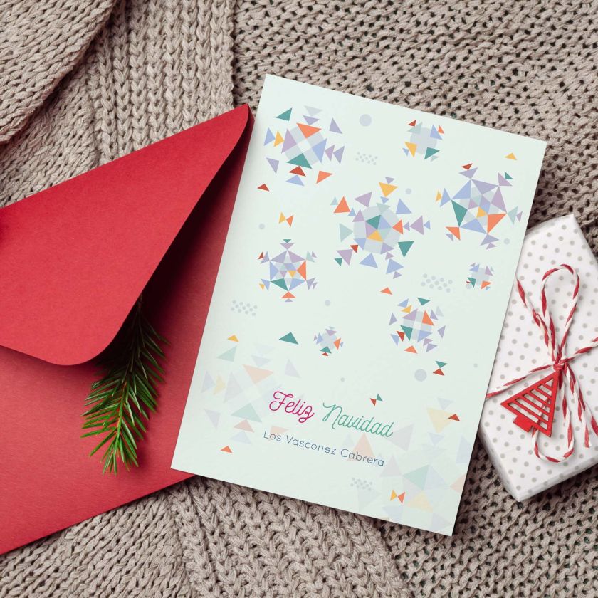 Tarjeta de Navidad personalizada con diseño geométrico y nombre de familia sobre fondo navideño con sobre rojo