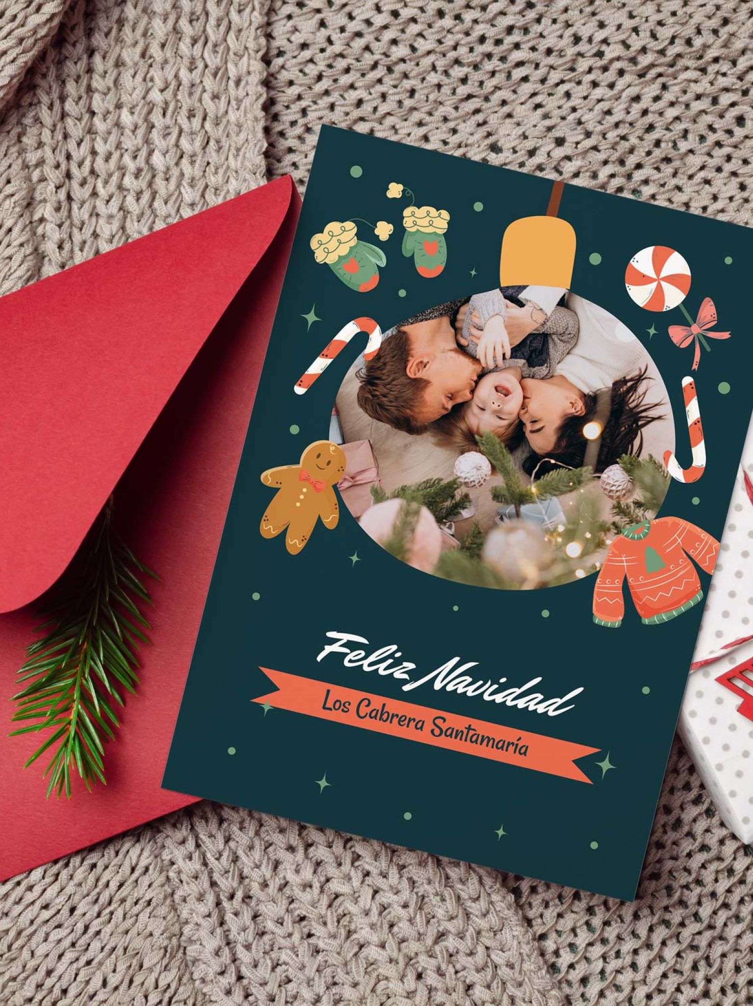 mockup de tarjeta navideña personalizable con foto sobre fondo navideño con sobre rojo y regalo