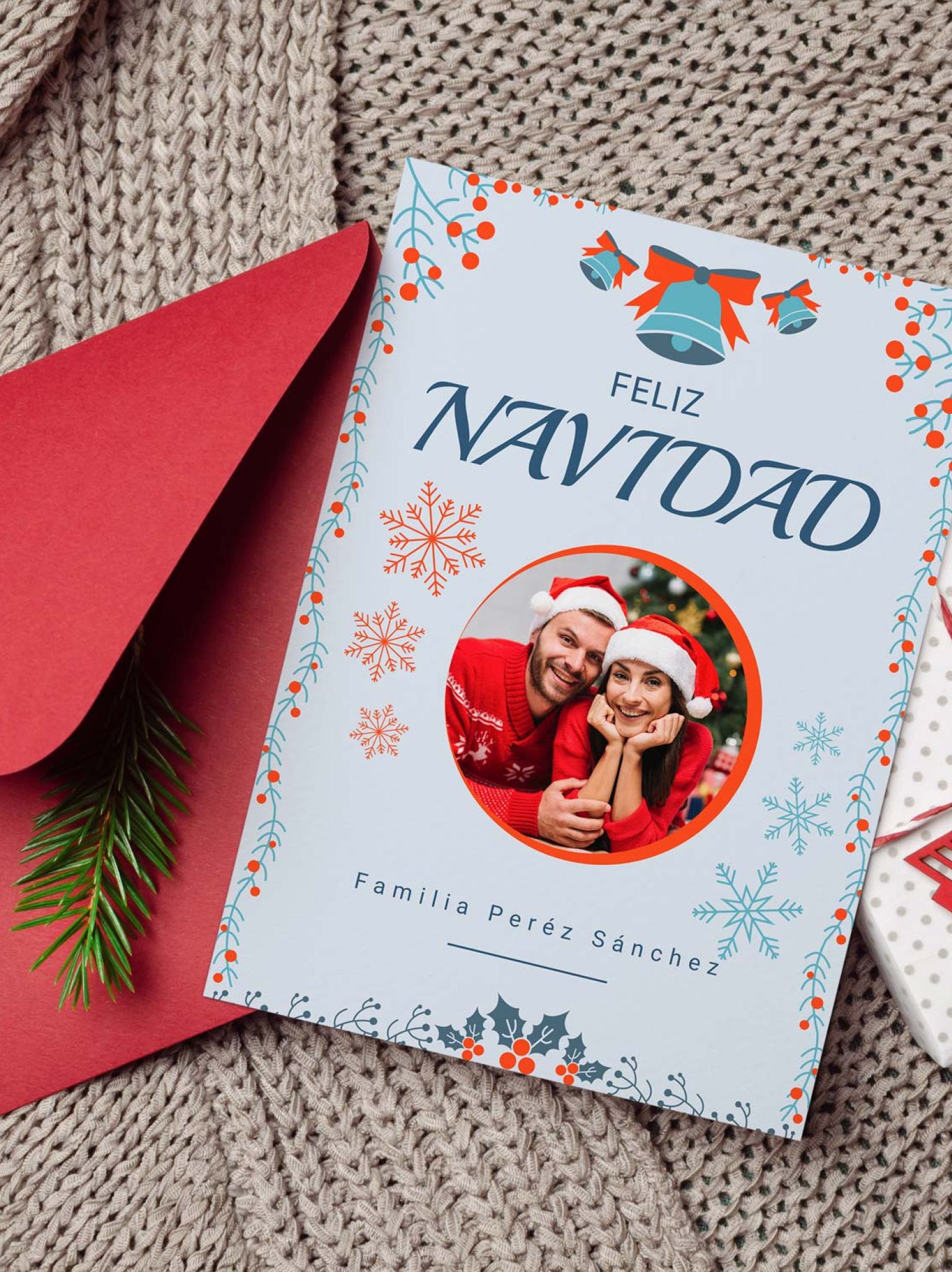 mockup de tarjeta navidad con foto personalizada junto a sobre rojo y decoraci&oacute;n navide&ntilde;a