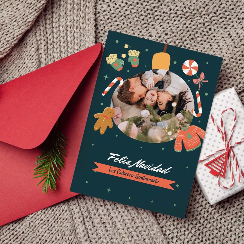 mockup de tarjeta navideña personalizable con foto sobre fondo navideño con sobre rojo y regalo