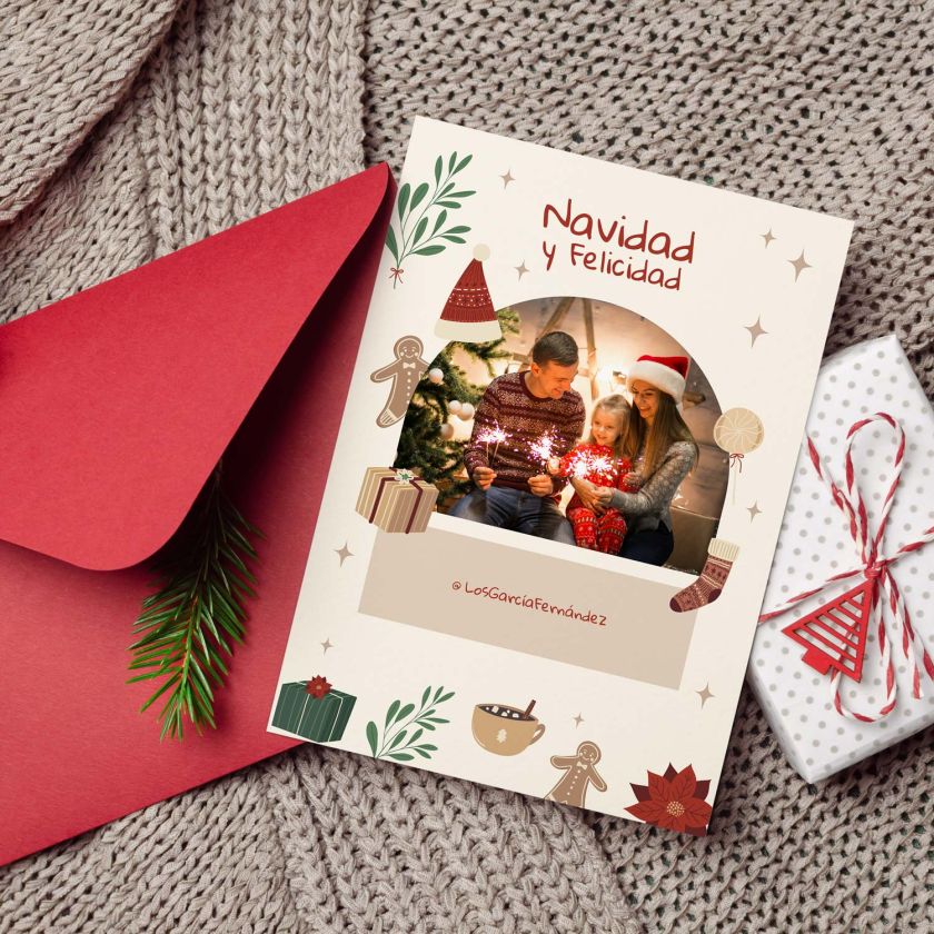 Mockup de tarjeta navideña con foto personalizada junto a sobre rojo y regalos en ambiente acogedor