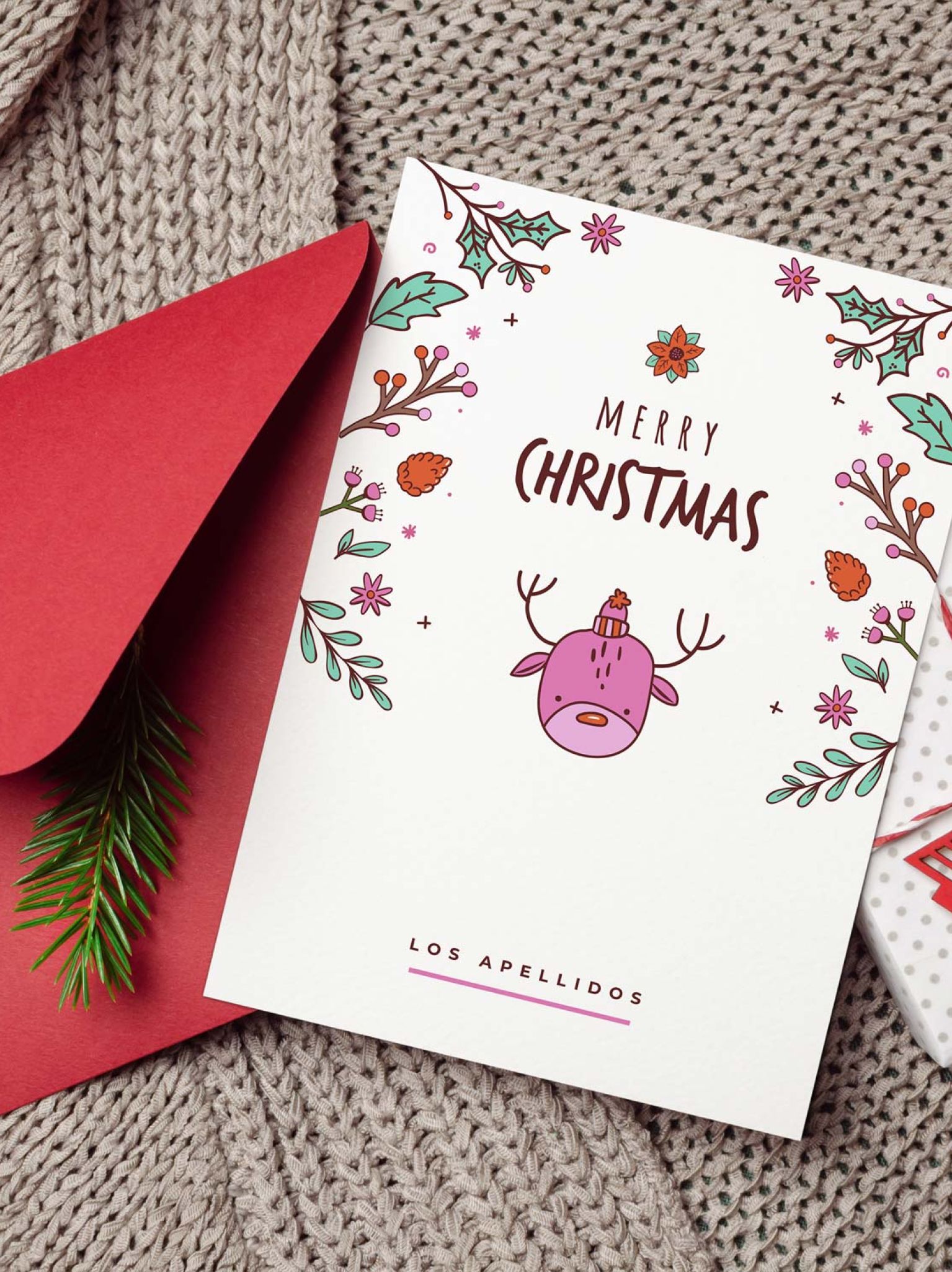 tarjeta navidad personalizada con reno ilustrado, sobre rojo y decoraci&oacute;n navide&ntilde;a