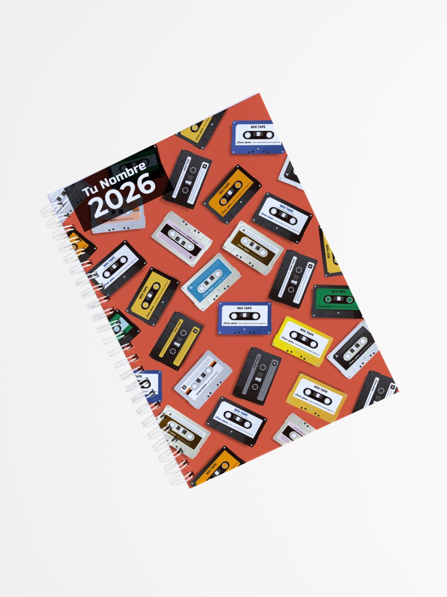 portada de libreta personalizada con fondo naranja y estampado de cintas de casete de colores, encuadernada con espiral lateral y texto “Tu Nombre 2026”