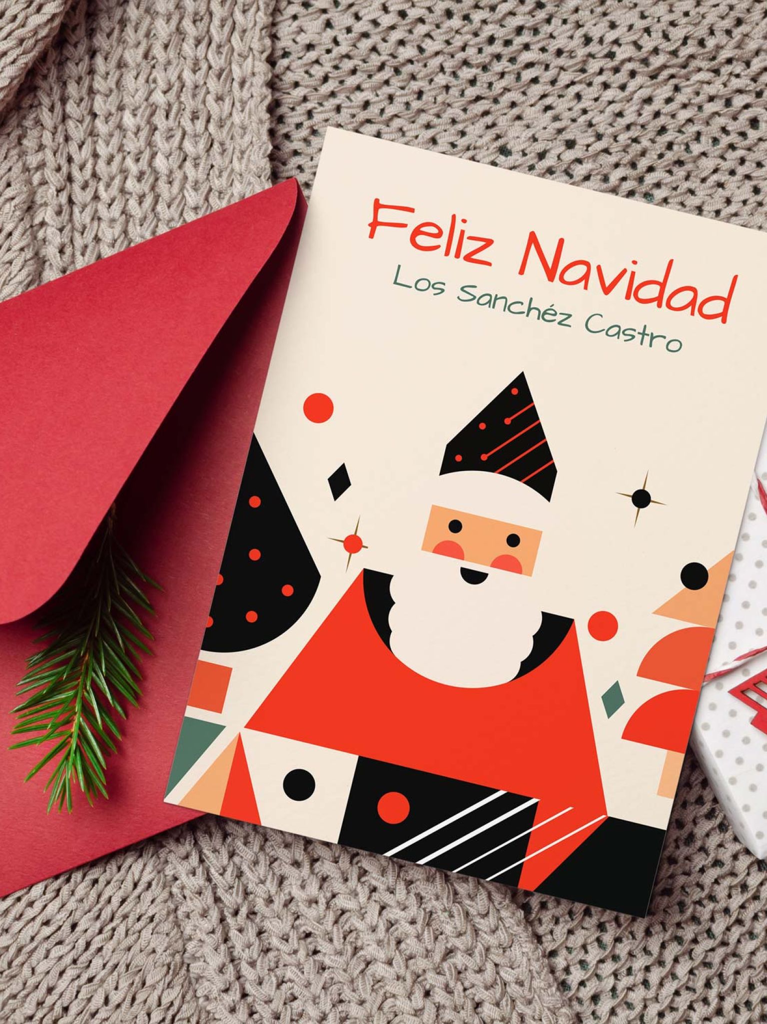 Mockup de tarjeta navideña personalizada con Papá Noel, sobre rojo y decoración sobre manta tejida